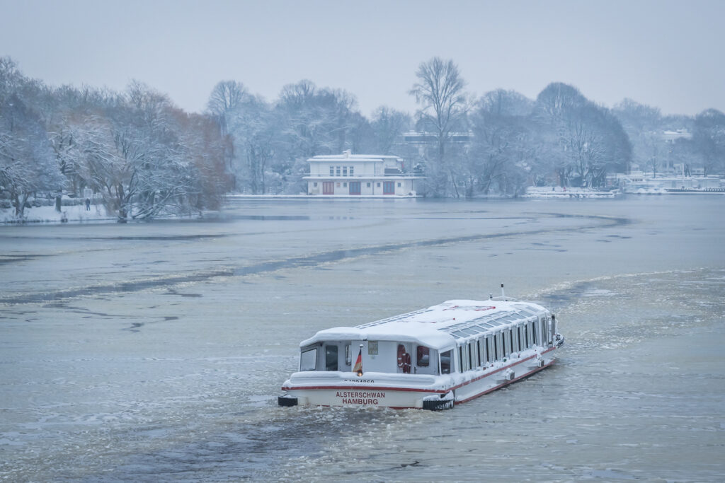 Schiff der Alstertouristik auf der vereisten Außenalster in Hamburg. Foto: Kerstin Bittner